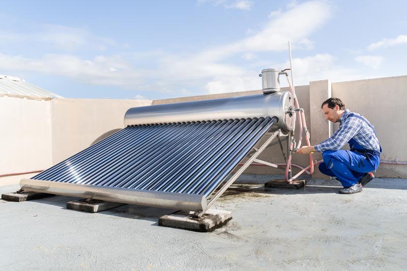 Technicien effectuant la maintenance d'un chauffe-eau solaire